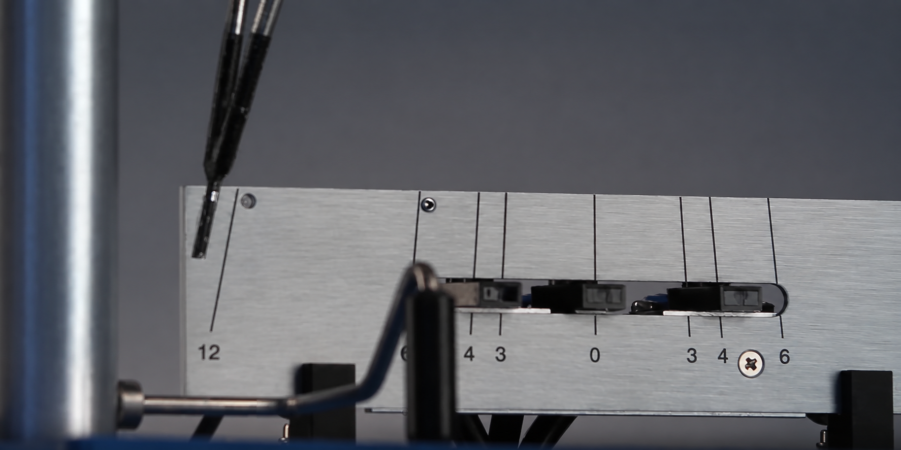 Close-up of a pendulum hardness tester, showing the pendulum arm and measurement scale